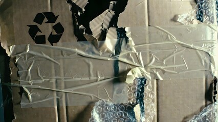 Taped up cardboard shipping box with recycling symbol and bubble wrap detail