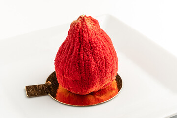 A stunning dessert resembling a vibrant red berry awaits to be savored, showcasing artistic detail