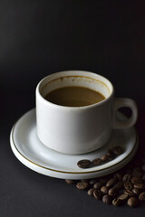 Fototapeta premium Cappuccino and coffee beans on a table with a dark background 