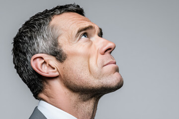Fototapeta premium European mature businessman executive looking upward in clean side profile portrait. Serious professional male leader contemplating career direction and long term strategy