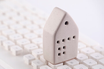 Small house on white computer keyboard