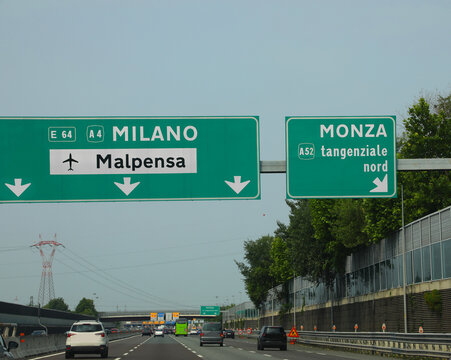 road sign with directions to the milan international airport called malpensa and the exit for the city of monza