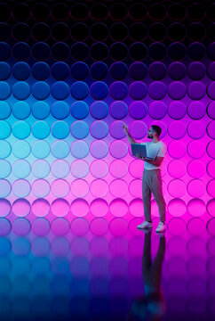 Man working with neon 3D tech glass circles background