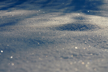 Close-up of sparkling snow surface with beautiful bokeh highlights