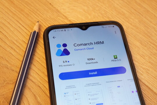 Comarch HRM app displayed on a smartphone screen next to a pencil