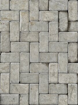 Gray concrete paving stone pattern background with interlocking design.