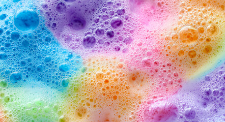 Colorful soap bubbles and foam forming an abstract texture with rainbow hues.