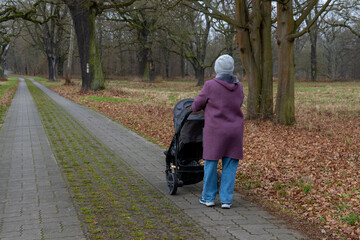 Dessau, Germany. December 23, 2025. A woman walks with a baby stroller
