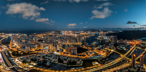 Aerial panoramic view of the illuminated city skyline and harbor at night in Macau.