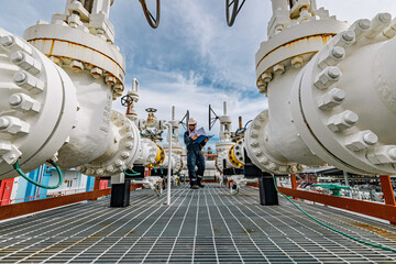 Male worker inspection at steel long pipes and pipe elbow in station oil factory during refinery valve of visual check record pipeline tank oil