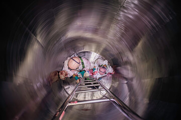 Top view male climbs up the stairs into the tank stainless chemical area confined