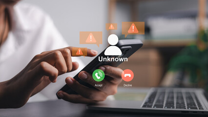 Close up of hands holding smartphone with unknown incoming call alert and warning icons, representing scam protection, cyber security and digital fraud prevention in modern office.