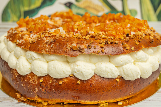 A freshly baked cream-filled rosc&oacute;n, cut in half, with subtle steam rising from the warm pastry as the cold cream begins to melt slightly upon contact