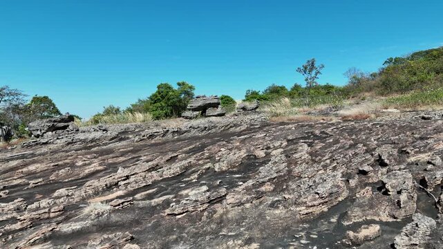 Drone aerial footage of Hin Pum stone formations at Phu Pha Phueng viewpoint in Kalasin UNESCO Global Geopark, Thailand, showcasing unique geology, natural landscape, and scenic horizon.