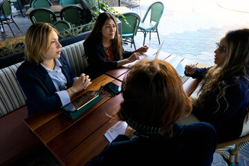 Professional women having business meeting at outdoor cafe