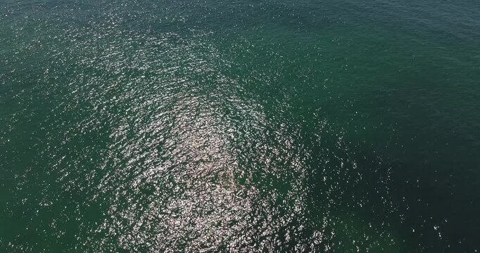 Aerial drone shot of shimmering turquoise Atlantic Ocean surface near Benagil, Algarve Portugal, water texture