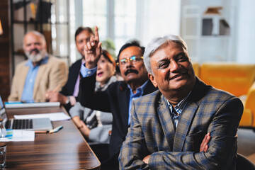 Senior Indian executives applauding successful business presentation in modern corporate office