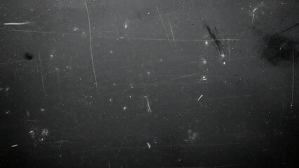 A close-up view of a worn, dark surface with scratches and marks, illustrating the texture and detail of aged materials from a direct perspective.