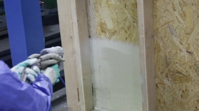 Insulation with special foam for walls, thermal insulation foam in the wall, a builder applies foam to the wall