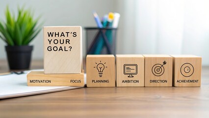 Wooden cubs spelling 'What's Your Goal' on table with supportive words and symbols