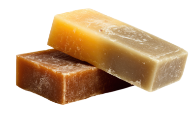Two bars of handmade soap, stacked, one light orange-yellow, one light brownish-gray, showing a slightly rough texture