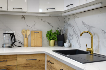 Kuchnia w apartamencie w jasnych kolorach , biel, brązowe fronty szafek, stolik śniadaniowy