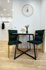 Kuchnia w apartamencie w jasnych kolorach , biel, brązowe fronty szafek, stolik śniadaniowy