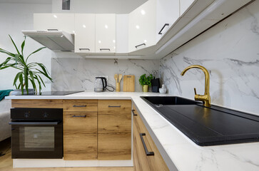 Kuchnia w apartamencie w jasnych kolorach , biel, brązowe fronty szafek, stolik śniadaniowy