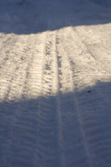 Tire tracks in deep white snow on a sunny winter day