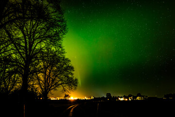 Northern lights dancing over country road in north of Sweden
