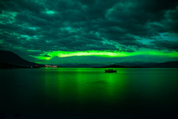 Northern lights dancing over calm lake in Abisko national park in north of Sweden