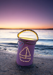 beautiful self crafted lantern with candle inside near the sea