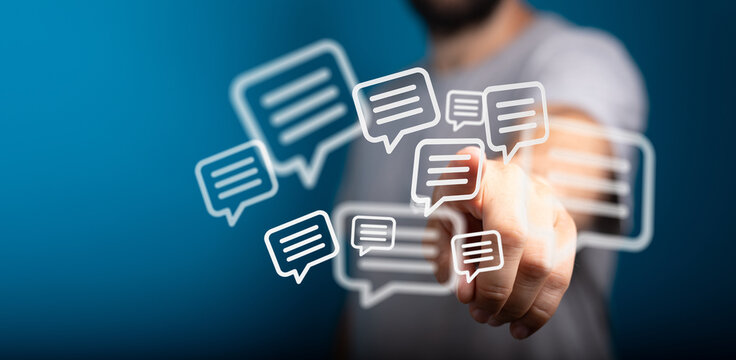 Person interacting with glowing message bubbles on a dark blue background, concept of communication and online messaging. - Powered by Adobe