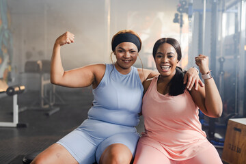 Diverse female friends posing and flexing in athletic wear on gym bench with dumbbells, earbuds