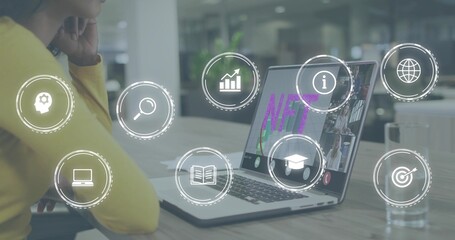 Sitting professional wearing yellow top viewing NFT laptop at table in office, HUD icons and glass