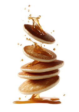 Stack of pancakes in mid-air, drizzled with syrup