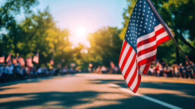 American flag waves over a parade scene in the daylight with people gathered along the street to celebrate
