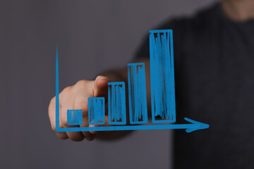Hand pointing at a graph representing business growth, success, and development in a visual...