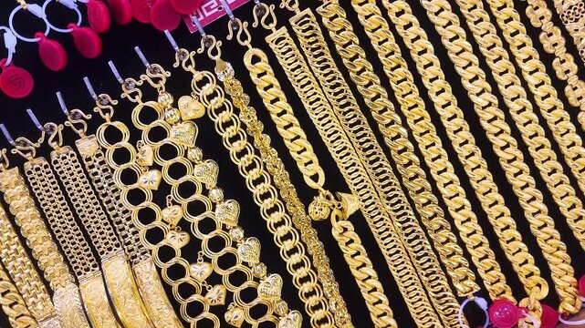 Gold jewelry, Rows of gold bracelet and necklaces displayed in jewelry store showcase, symbolizing wealth, investment, and luxury. Perfect for financial, economic, or gold market concepts