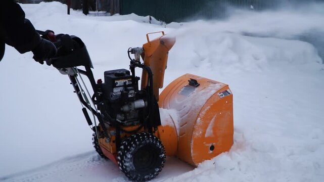 A portable snow blower powered by gasoline. Snow removal in winter.