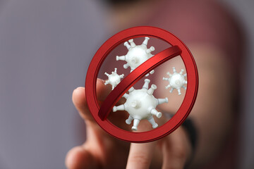 Concept image: Hand touching a sign prohibiting viruses, symbolizing the fight against illness and protection