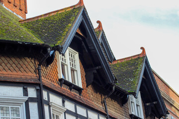Beautiful Oxford architecture. Old brick building with fairytale moldy roof. Clay chimney pots on the top of red brick chimney stack of the English building.