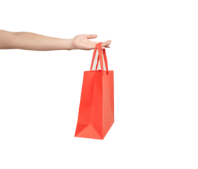 A person's hand holding a paper shopping bag with handles on a clean white background. Studio shot with ample copy space for text, logos, or branding. Isolated on white, cut out.