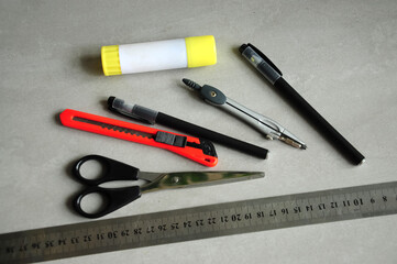 flat lay of stationery tools including scissors cutter compass pens ruler and highlighter on gray background school office supplies education creativity workspace concept