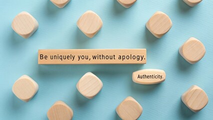 Wooden blocks with inspirational quotes about authenticity and self-expression arranged on a light blue surface