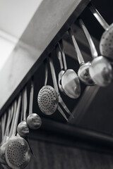 Cooking Spoons and Ladles Hanging in Kitchen