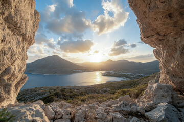 Rock cave framing coastal bay sunset in greece