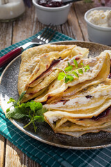 Crepes with ricotta cheese and blackcurrant jam.