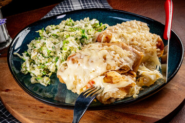 Stuffed pancakes under a cheese blanket.