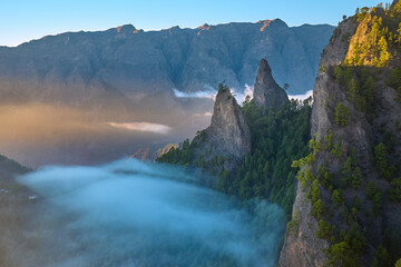 Aerial sunrise view of a volcanic mountain amphitheater filled with a sea of clouds in Parque Nacional de la Caldera de Taburiente 